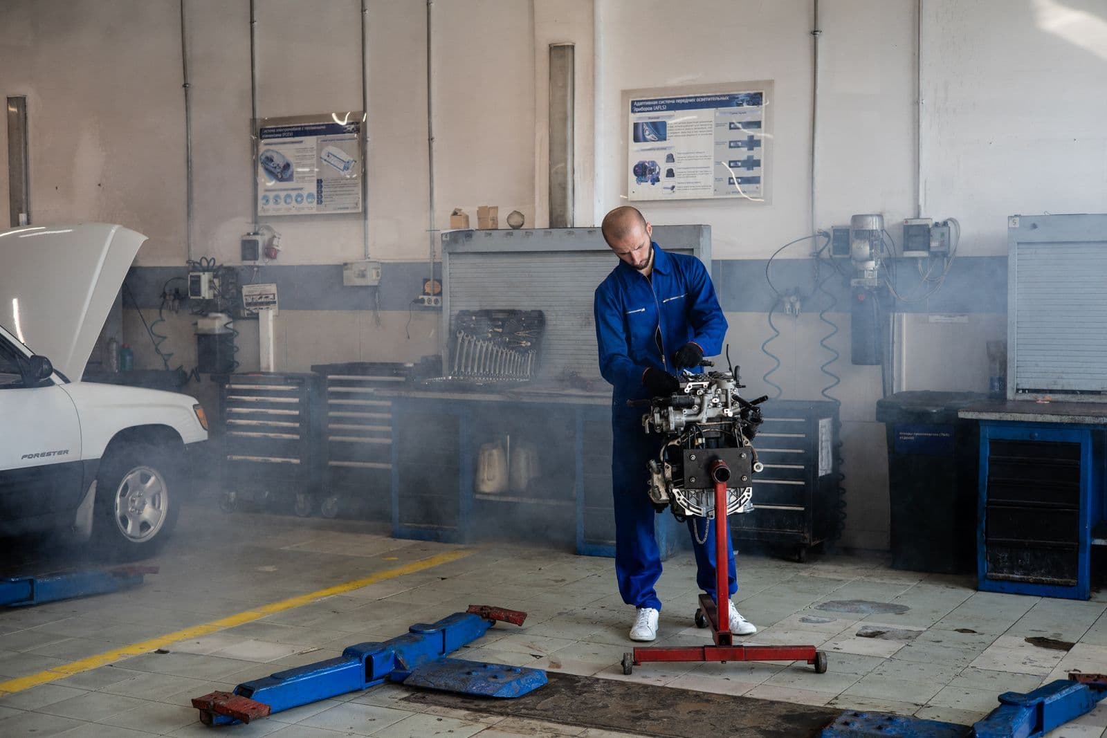 A mechanic working on an engine in a workshop